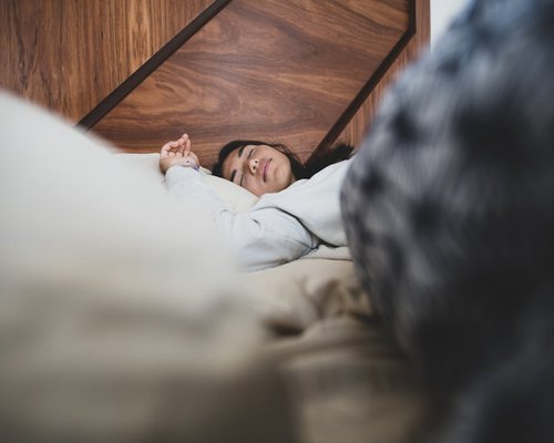 Person sleeping comfortably in cozy bedroom